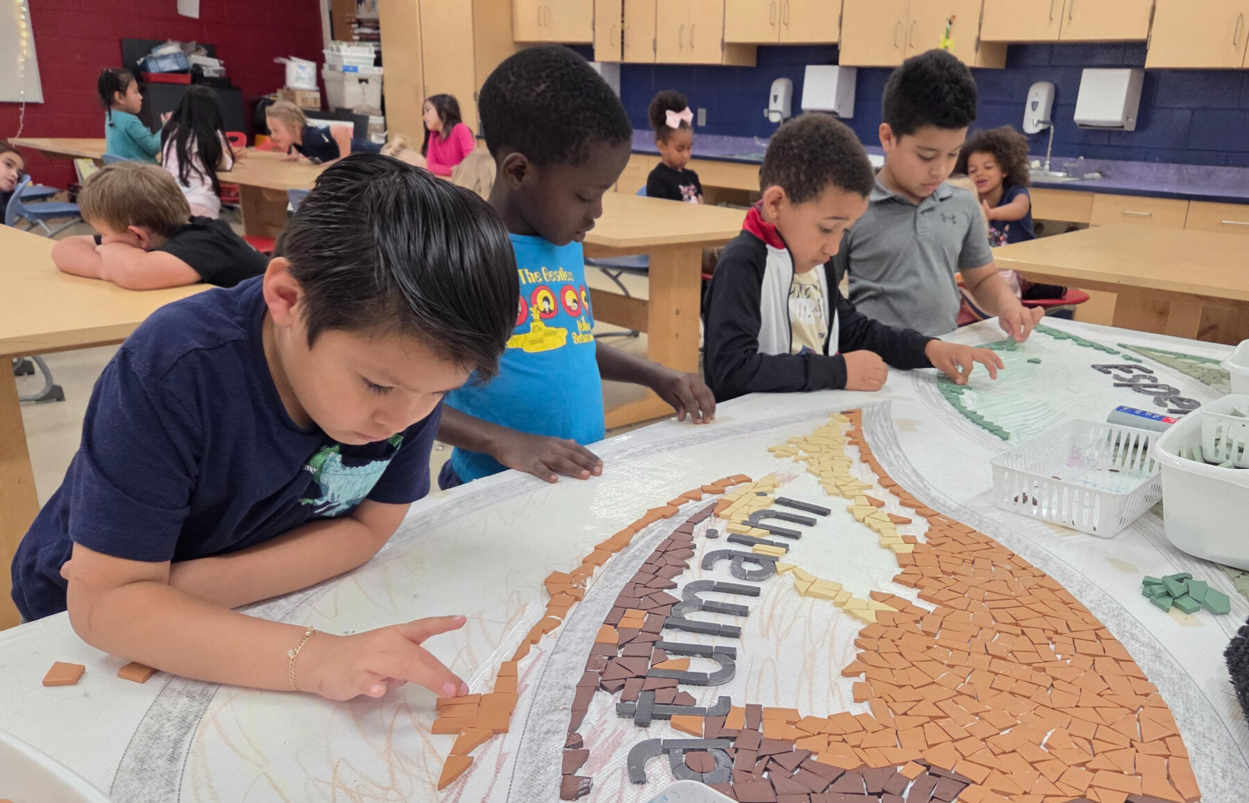 Mosaic Institute Group of young children working on a mosaic project on a table